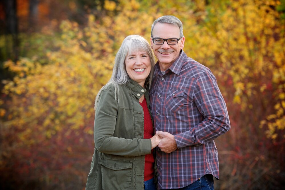 Family image of Wayne Vinson and his Wife Annie Vinson infront of autumn trees.